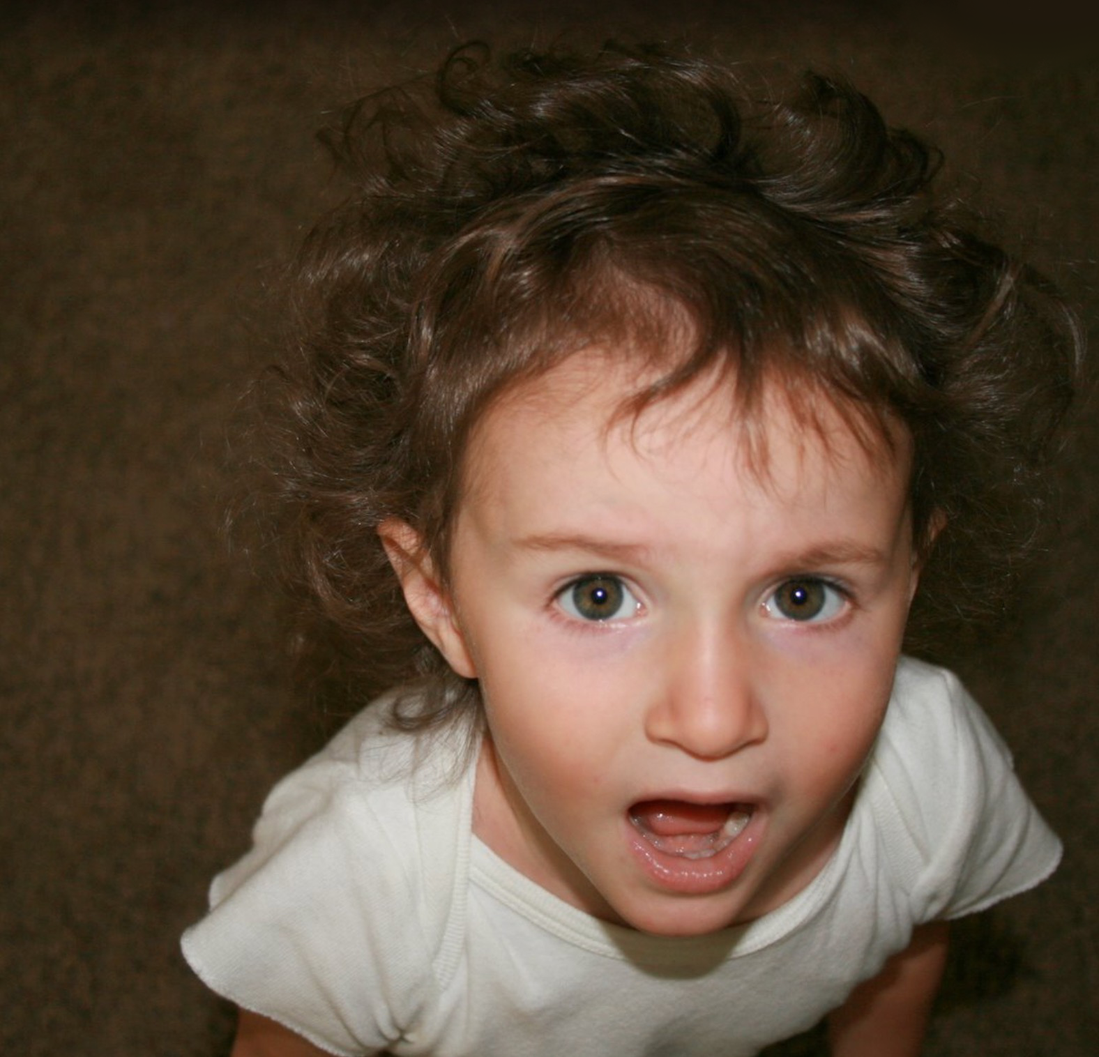 Picture of toddler Attalie staring up at the us, mouth agape, looking rather upset.